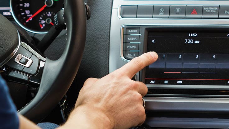 Close-up of a man touching dashboard with finger.