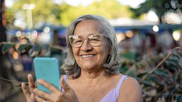 Gray-haired elderly woman using smartphone
