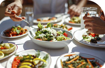 Couple Eating Lunch with Fresh Salad and Appetizers