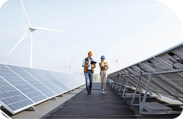 View on the rooftop solar power plant with two engineers walking and examining photovoltaic panels. Concept of alternative energy and its service