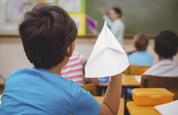 Pupil about to throw paper airplane at the elementary school