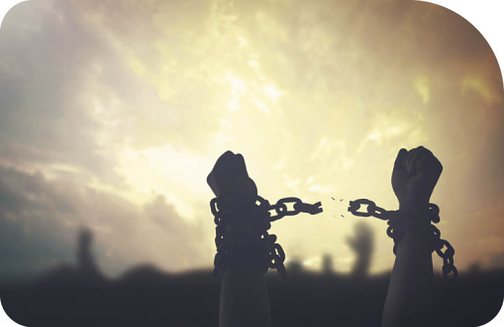 Silhouette human hands raising and broken chains at sunset background