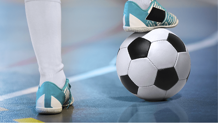 Indoor soccer sports player with ball. Football futsal player, ball, futsal floor. Sports background. Youth futsal league. Indoor football players with classic soccer ball.