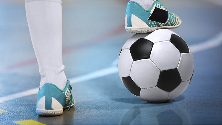 Indoor soccer sports player with ball. Football futsal player, ball, futsal floor. Sports background. Youth futsal league. Indoor football players with classic soccer ball.