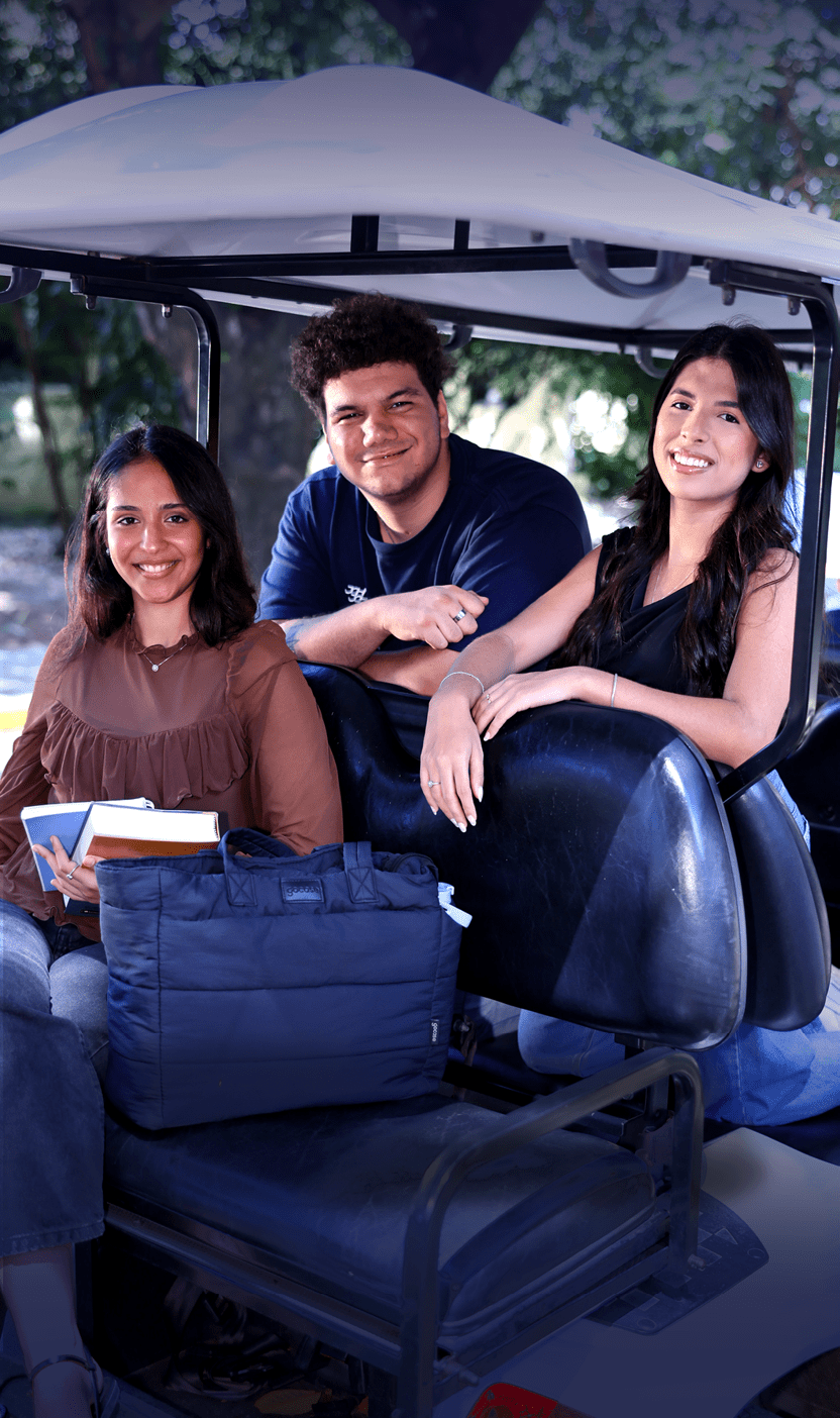 Tr s pessoas sorridentes est o sentadas em um carrinho de golfe ao ar livre, uma segurando livros e outra com uma bolsa azul ao lado. Description generated by AI