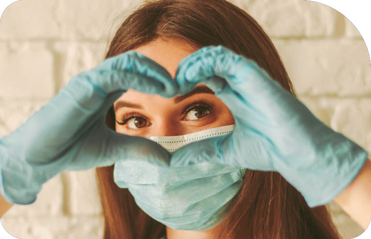 Banner young woman in protective face mask and medical gloves gesturing love shape sign  Happy girl in medical face mask and gloves looking through hands in form of heart symbol  Health care, COVID-19