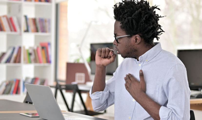 Sick Coughing African Man Working on Laptop