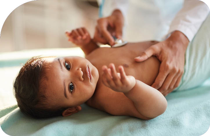 African newborn lying on back while doctor listening to his heartbeat with stethoscope at hospital