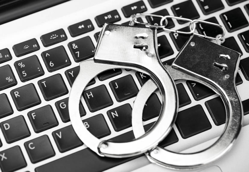 Handcuffs on laptop keyboard  Hacker cyber attack  Closeup