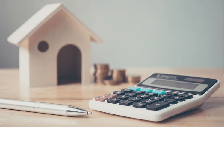 Calculator with wooden house and coins stack and pen on wood table  Property investment and house mortgage financial concept